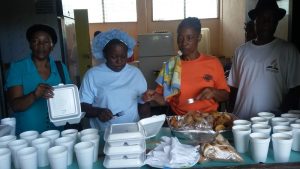 Adventist volunteers prepare to serve supper for residents of Petite Savanne one of the most affected by Tropical Storm Erika which hit the Caribbean Island of Dominica on Aug. 17, 2015. ADRA and the Roseau Community Services have been providing three meals every day to about 120 people since the shelters were opened in Dominica. Credit: ANN/ADRA Dominica.