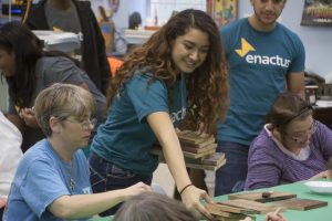 Enactus member Bianca helps COI clients with their painting projects that will become project for Beeyond Designs. Photo by Darcy Force, used by permission.